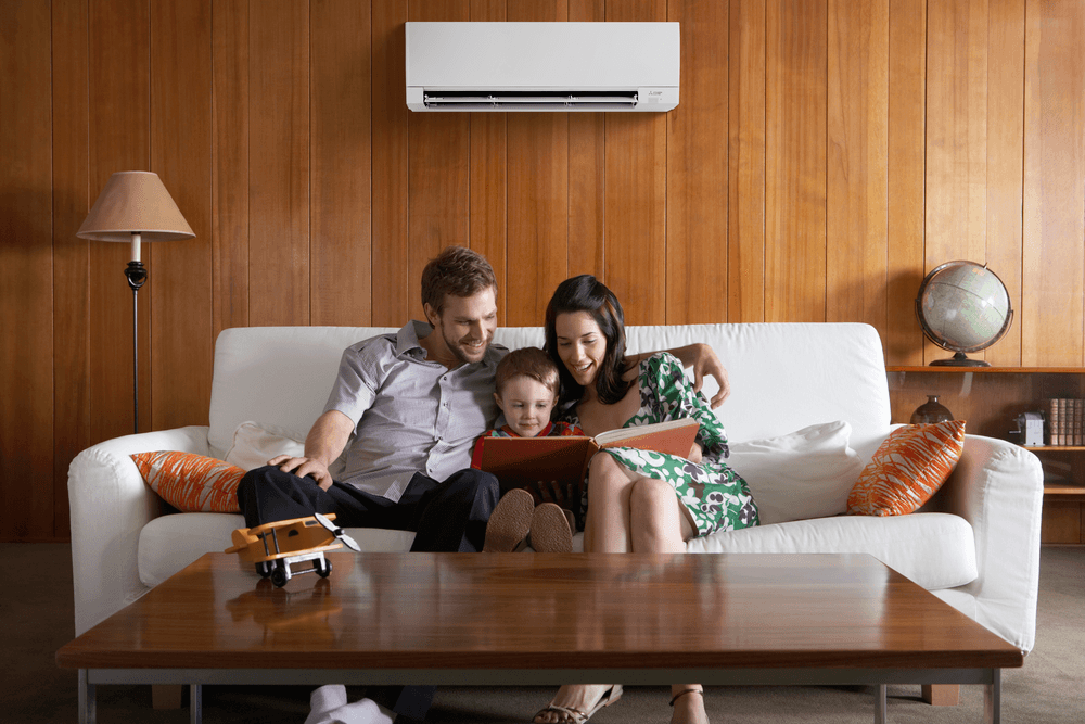 Family enjoying comfort from Mitsubishi mini split in wood-paneled living room