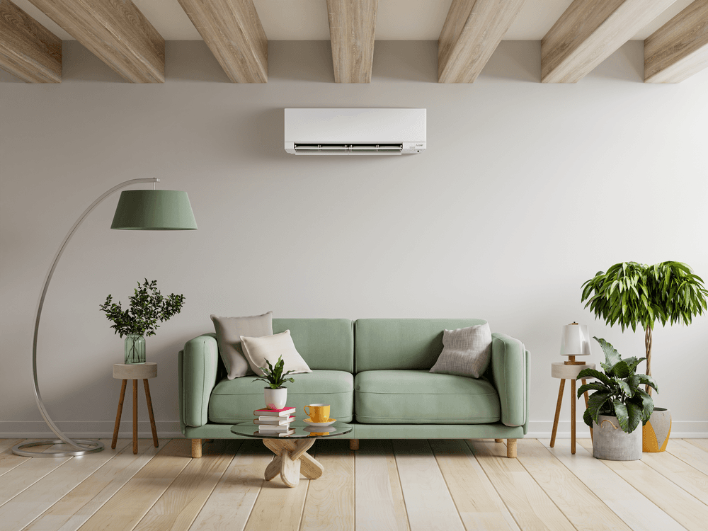 Mitsubishi ductless mini split installed above living room couch with exposed beam ceiling